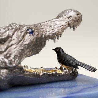 Patinated sterling silver crocodile sculpture with gold and black ruthenium plating, sapphire eyes and a Willy Wagtail with diamond eyes, mounted on a blue aventurine stone base.