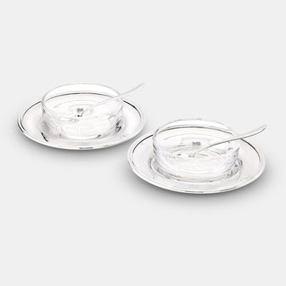 A refined pair of cruet dishes designed for salt, pepper or condiments. Each set features a sterling silver plate with a plain crystal bowl and matching sterling silver spoon, combining clarity and brilliance in a timeless table accessory.