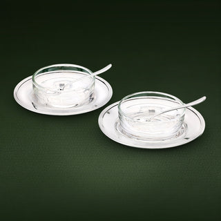 A refined pair of cruet dishes designed for salt, pepper or condiments. Each set features a sterling silver plate with a plain crystal bowl and matching sterling silver spoon, combining clarity and brilliance in a timeless table accessory.