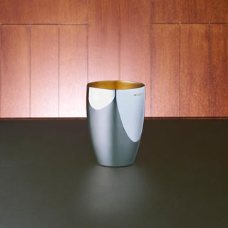 Australian Sterling Silver curve beaker with a polished exterior and matte gold-plated interior. 9.5cm tall and accommodating for a volume of 250mL.