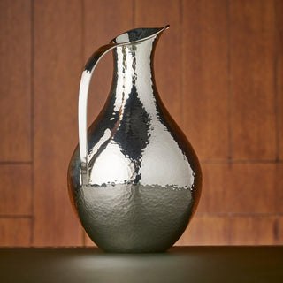 Sterling Silver bellied jug featuring a curved handle and hammered finish.