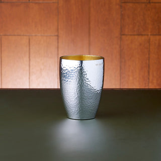 Australian Sterling Silver curve beaker with hammered, textured exterior and matte gold-plated interior. 9.5cm tall and accommodating for a volume of 250mL.