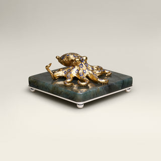 Sterling silver Blue Ringed Octopus sculpture with blue enamel, yellow gold plating and sapphire eyes, mounted on a labradorite stone base.