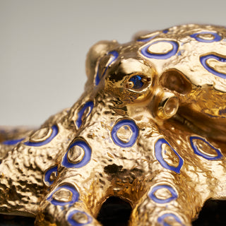 Sterling silver Blue Ringed Octopus sculpture with blue enamel, yellow gold plating and sapphire eyes, mounted on a labradorite stone base.
