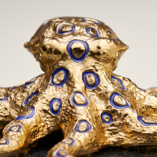 Sterling silver Blue Ringed Octopus sculpture with blue enamel, yellow gold plating and sapphire eyes, mounted on a labradorite stone base.