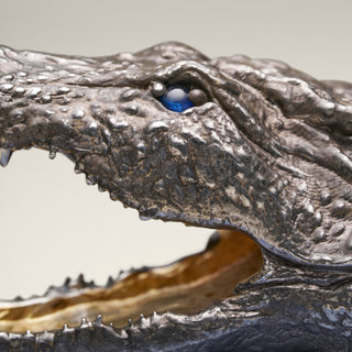 Patinated sterling silver crocodile sculpture with gold and black ruthenium plating, sapphire eyes and a Willy Wagtail with diamond eyes, mounted on a blue aventurine stone base.
