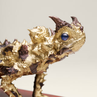 Sterling silver Thorny Devil sculpture with yellow gold plating, copper detailing and sapphire eyes, mounted on a red jasper stone base.