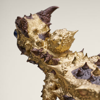 Sterling silver Thorny Devil sculpture with yellow gold plating, copper detailing and sapphire eyes, mounted on a red jasper stone base.
